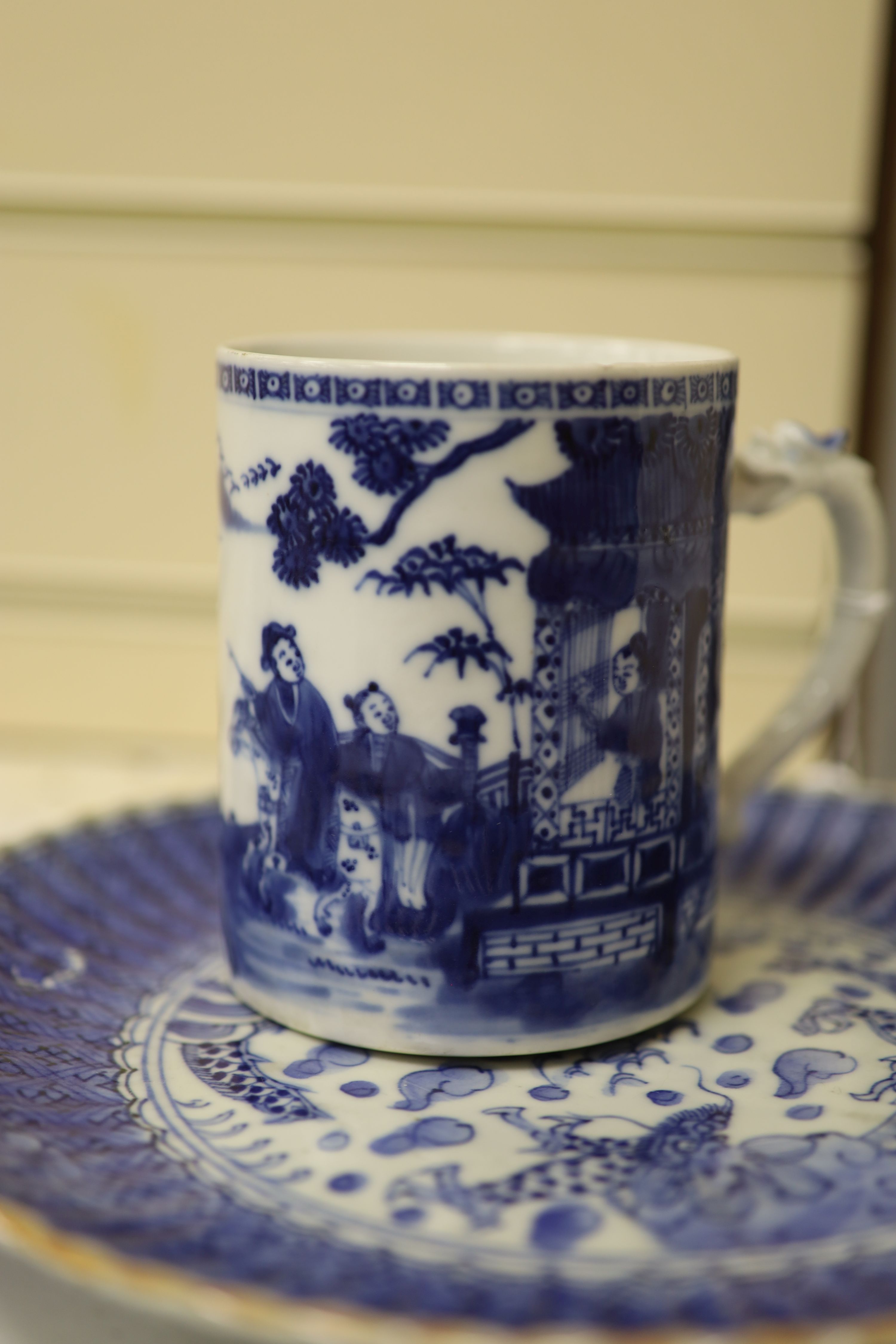 An 18th century Chinese blue and white mug and cup, a 19th century Chinese blue and white plate and a Japanese plate